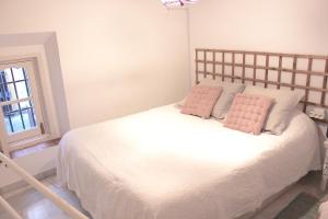 セビリアにあるApartamento en el Corazón de Sevillaのベッドルーム(ピンクの枕が付いた白いベッド付)