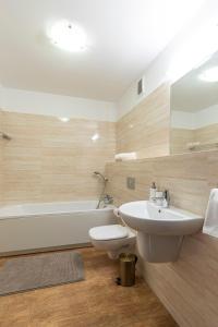 a bathroom with a sink and a toilet and a tub at Apartament Brandy in Szczecin