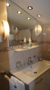 a bathroom with a sink and a mirror at Pension Hartenfels in Lech am Arlberg +96 photos