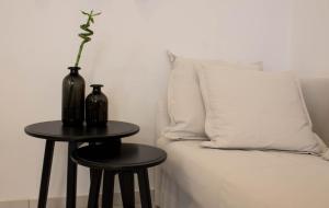 a table with two stools next to a bed with a pillow at Super Stylish Apartments in Syntagma Square! in Athens
