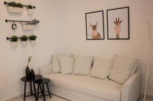 a white couch in a living room with pictures of deer at Super Stylish Apartments in Syntagma Square! in Athens