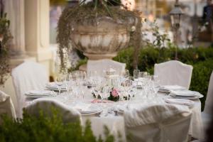 a table with glasses and plates and a fountain at Hotel Villa Margherita in Quercianella