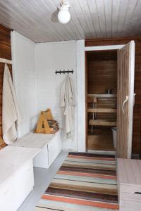 a bathroom with a bench and a closet with a robe at Mertala Raijan Aitta in Mikkeli