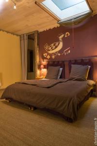 a bedroom with a bed with a painting on the wall at Marie Colline à la Campagne in Saint-Antonin