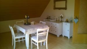 una sala da pranzo con tavolo e sedie bianchi di Ferienwohnung Mai a Gittelde
