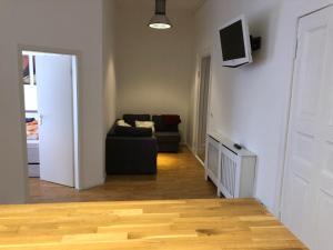 salon z kanapą i telewizorem na ścianie w obiekcie City-Apartment Zille w Berlinie