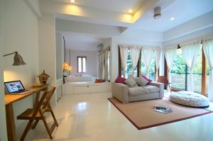 a living room with a couch and a desk and some windows at Proud Phu Fah Maerim Resort in Mae Rim +241 photos