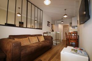 a living room with a brown couch and a table at Duplex climatisé en Hyper Centre de Bordeaux in Bordeaux