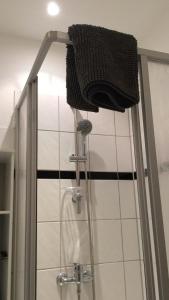 um chuveiro com uma cabeça de chuveiro e uma toalha em City-Apartment Zille em Berlim