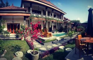 a house with a swimming pool in front of it at Pondok Ayu Homestay in Ubud