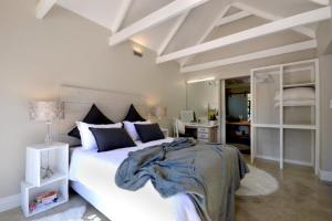 een slaapkamer met een groot wit bed in een kamer bij SAFFRON COTTAGE in Hermanus
