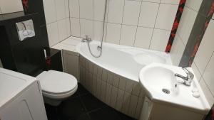 een badkamer met een bad, een toilet en een wastafel bij Apartament Boróweczka in Polkowice