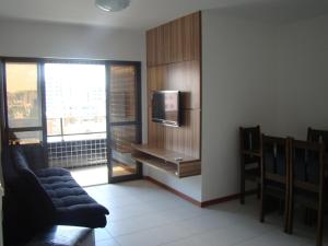 sala de estar con TV, sofá y ventana en Apt 2 quartos acomoda 10 pessoas a 450 metros da praia de Jatiúca, en Maceió