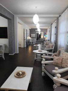 una sala de estar con varios sofás y mesas. en Hotel Panorama, en Chianciano Terme