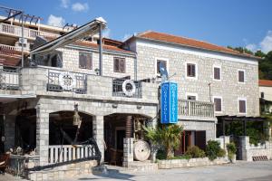 um grande edifício de pedra com um sinal azul em Suntime apartment em Tivat