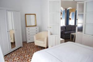 コルドバにあるCasa con encanto junto Mezquitaのベッドルーム(ベッド1台、椅子、鏡付)