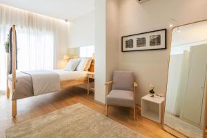 um quarto com uma cama, uma cadeira e um espelho em Inn Oporto Downtown New Apartments no Porto