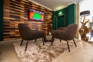 a room with three chairs and a tv on a wall at Castro Marim Golfe and Country Club in Castro Marim