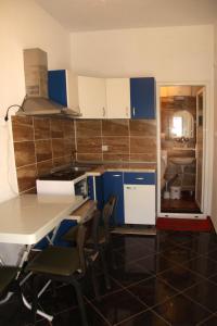 een keuken met blauwe en witte kasten en een tafel en stoelen bij Dani-Ban in Star Dojran