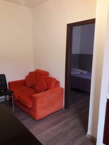 un divano rosso in soggiorno con specchio di Casa Belzoni a Padova