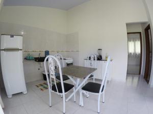 a kitchen with a table and chairs and a refrigerator at Casa em Pipa 2 quartos in Pipa