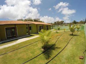 a house with palm trees in front of a yard at Casa em Pipa 2 quartos in Pipa
