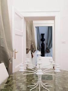 a room with white chairs and a mirror at CharmeRooms Palazzo Stampa in Bergamo