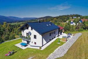 a white house with a blue roof on a green field at Panoramablick in Mauth