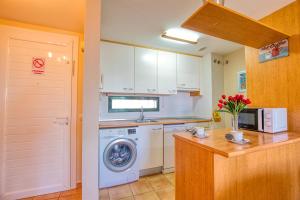 eine Küche mit Waschmaschine und Mikrowelle in der Unterkunft Paraiso 1 Sea view - TENESOL RENTALS in Playa Paraiso