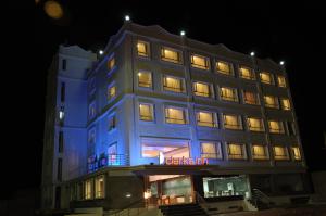 a lit up building with a blue lit up at Grand Clarks Inn in Badami