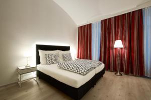 a bedroom with a bed and red curtains at Pension am Wienfluss in Vienna