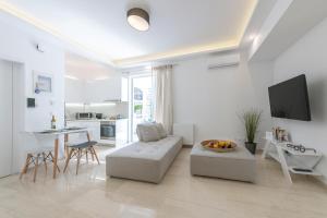 ein weißes Wohnzimmer mit einem Sofa und einem Tisch in der Unterkunft MeliDi Luxury Penthouse in Koukaki in Athen