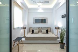ein Schlafzimmer mit einem Bett in einem weißen Zimmer in der Unterkunft MeliDi Luxury Penthouse in Koukaki in Athen