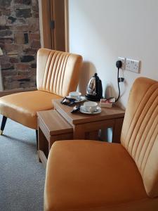 two chairs sitting next to a table with a telephone at Croft Guesthouse in Cockermouth