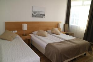 a hotel room with two beds and a window at Arctic Comfort Hotel in Reykjavík