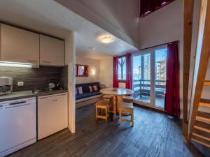 a kitchen with a table and a small table with a window at Castor & Pollux in Risoul