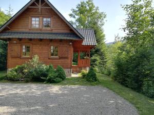drewniany dom z podjazdem przed nim w obiekcie Dom pod Jesionami w mieście Ochotnica Dolna