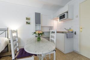 a small kitchen with a table with a vase of flowers on it at Résidence La Villa Léonie in Nice