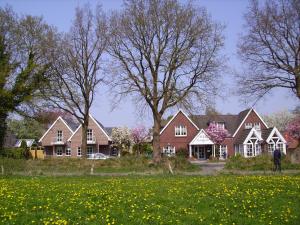 a group of houses in a field of flowers at Hotel Waldquelle in Aurich