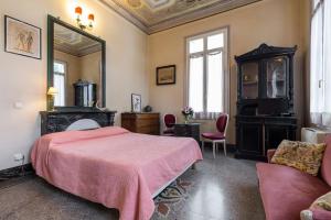 a bedroom with a pink bed and a mirror at Résidence La Villa Léonie in Nice