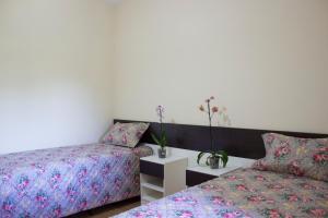 a bedroom with two beds and a table with flowers at Pousada Rural Águas da Prata in Águas da Prata