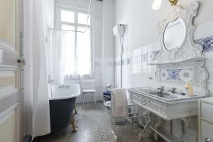 a white bathroom with a tub and a sink and a bath tub at Résidence La Villa Léonie in Nice