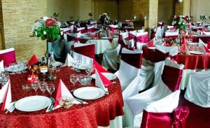 un grupo de mesas con mesas rojas y blancas en Hotel Casa de Piatra en Scheia