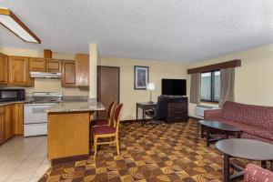 a living room with a kitchen and a living room at AmericInn by Wyndham Elkhorn Near Lake Geneva in Elkhorn