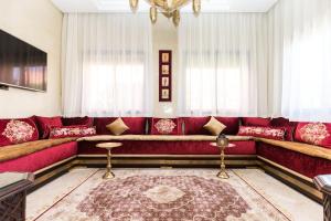 a living room with a red couch and a rug at VILLA ILYANA in Marrakesh