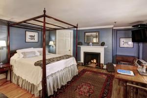 1 dormitorio con cama con dosel y chimenea en 200 South Street Inn, en Charlottesville