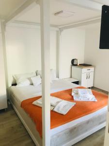 una camera da letto con due letti con lenzuola arancioni di Guest House Ratko a Rafailovici Altre 26 foto