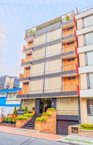 a tall apartment building with stairs in front of it at Hotel Regency Suites La Feria in Bogotá