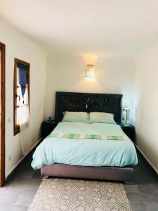 a bedroom with a large bed with a wooden headboard at Dar Christine in Marrakesh