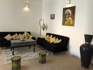 a living room with two black couches and a table at Dar Christine in Marrakesh